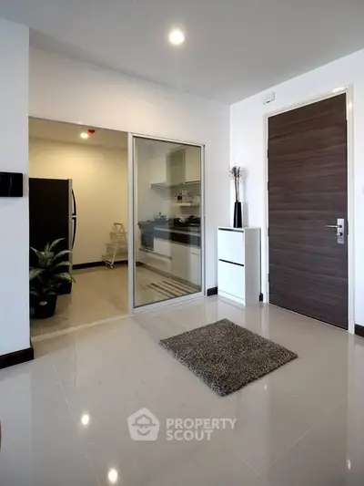 Modern apartment entrance with sleek kitchen view and stylish decor