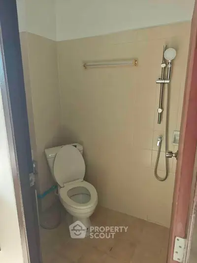 Compact bathroom with modern shower and toilet in a cozy home setting.