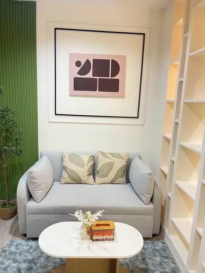 Chic living room with modern sofa, stylish artwork, and elegant shelving, perfect for cozy relaxation.