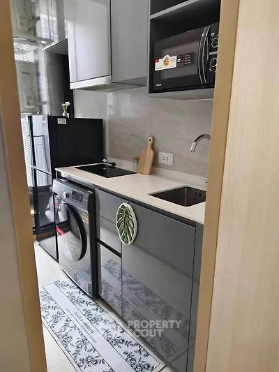 Modern kitchen with sleek appliances and stylish cabinetry in a compact layout.
