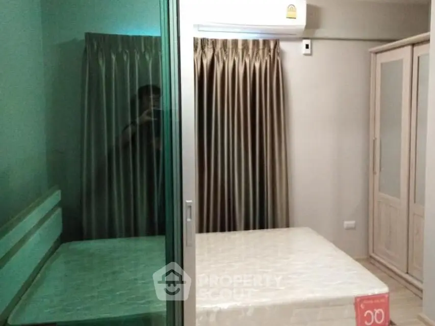 Cozy bedroom with mirrored wardrobe and air conditioning in modern apartment.
