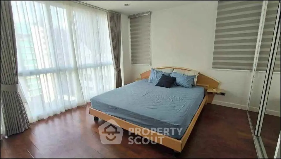 Spacious bedroom with large windows and modern decor in a stylish apartment.