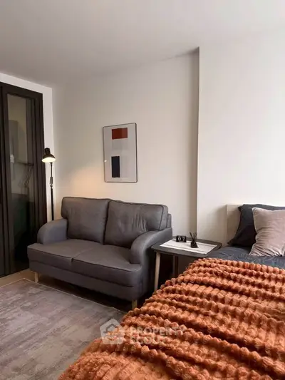 Cozy modern living room with stylish sofa and textured blanket, perfect for relaxation.