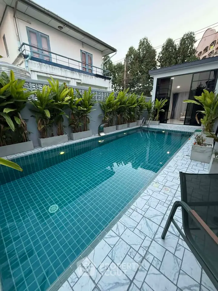 Luxurious private pool area with lush greenery and modern design, perfect for relaxation and entertainment.