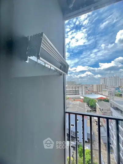 Stunning city view from a modern balcony with sleek railing and clear blue skies.