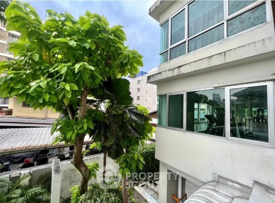 Modern building exterior with lush greenery and large windows