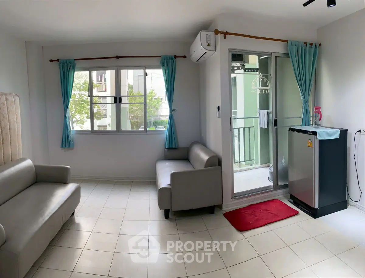 Bright living room with modern furniture and balcony access, perfect for relaxation and entertaining.