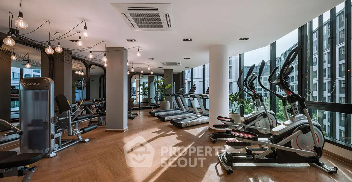Modern gym with state-of-the-art equipment and large windows offering a city view.
