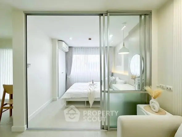 Modern minimalist bedroom with sliding glass doors and soft natural lighting.