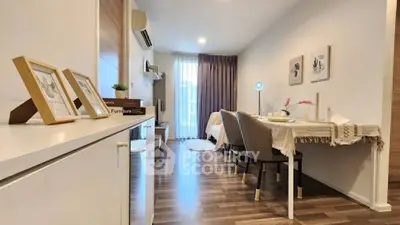 Modern living room with stylish decor and dining area, featuring wooden flooring and natural light.