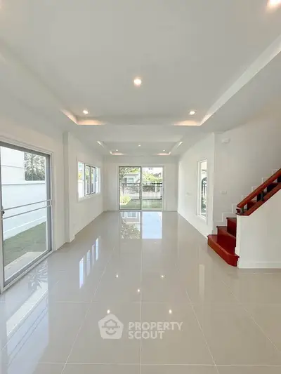 Spacious modern living room with glossy tile flooring and large windows for natural light.