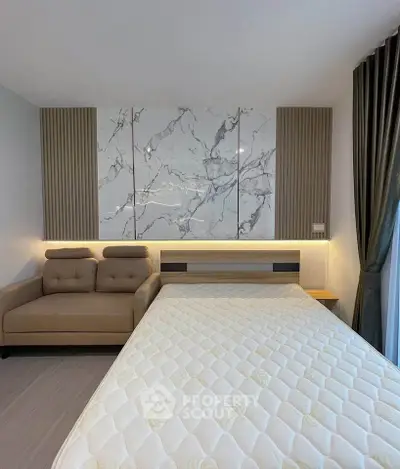 Modern bedroom with stylish marble accent wall and cozy sofa