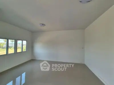 Spacious empty room with large windows and glossy tiled floor, perfect for customization.