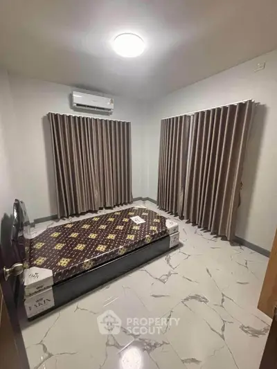 Spacious bedroom with modern air conditioning and elegant curtains