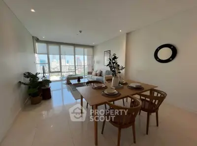 Spacious modern living room with dining area and city view, featuring elegant decor and natural light.