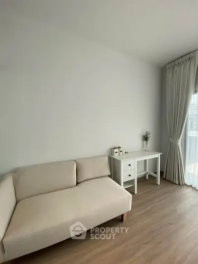 Minimalist living room with beige sofa and white curtains, perfect for modern living.