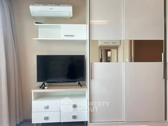 Modern living room with sleek TV stand and air conditioning unit, perfect for cozy entertainment.