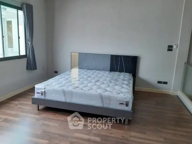 Spacious bedroom with modern bed and hardwood flooring