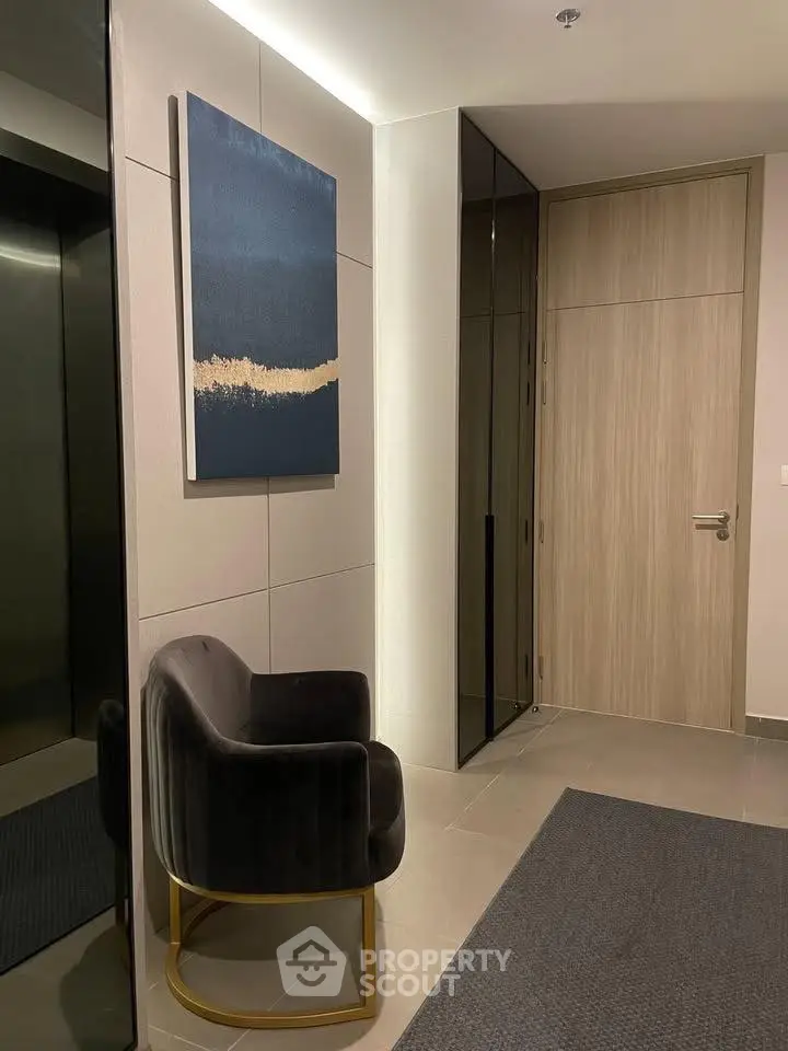 Stylish modern apartment entrance with elegant chair and artwork