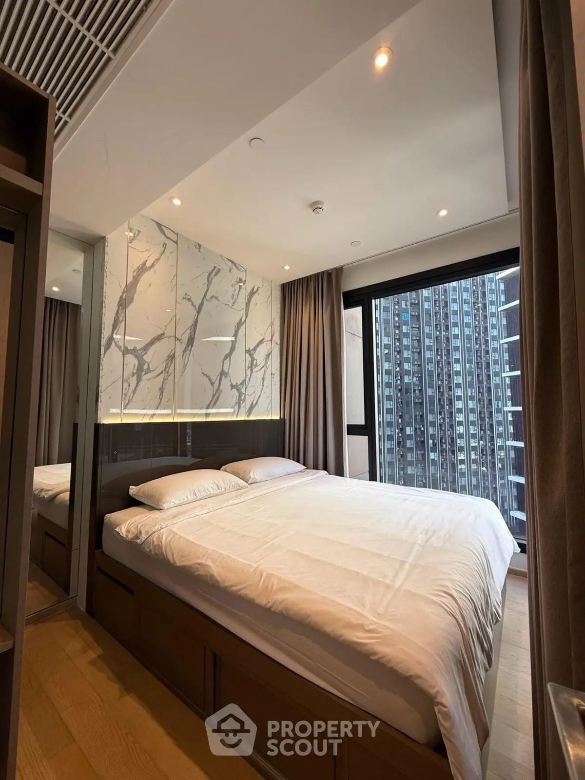 Luxurious bedroom with modern design and city view in high-rise apartment