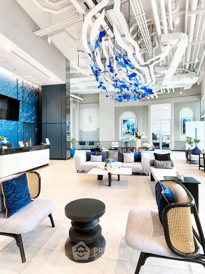 Luxurious modern lobby with elegant seating and artistic ceiling decor in a high-end building.