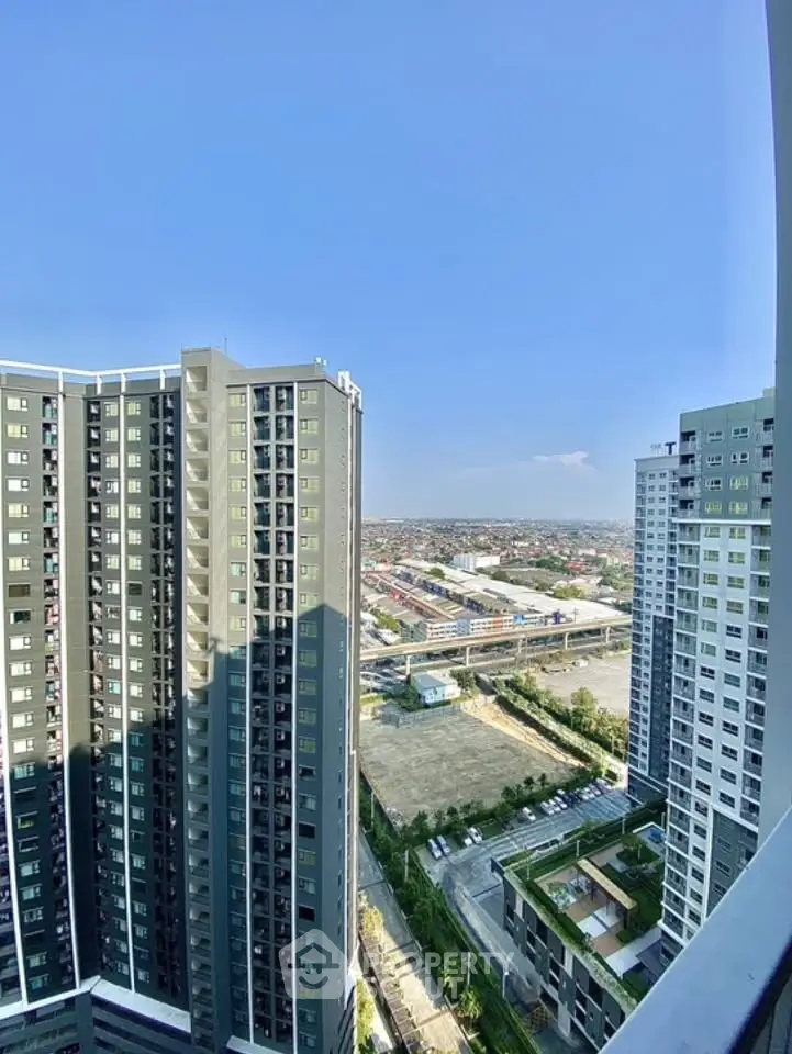 Stunning high-rise apartment view with expansive cityscape and clear blue sky.