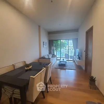 Spacious living room with modern decor and large windows offering city views.