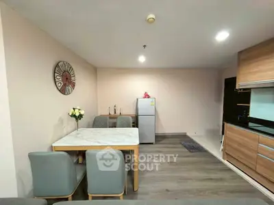 Modern kitchen with dining area, featuring sleek appliances and stylish decor.