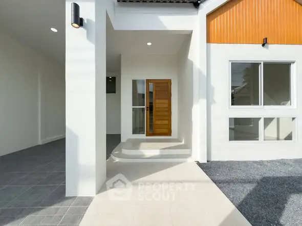 Modern home entrance with stylish wooden door and sleek exterior design.
