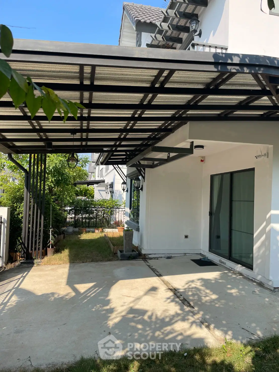 Modern house with covered carport and lush garden, perfect for family living.