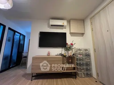 Modern living room with sleek wooden furniture and wall-mounted TV, featuring minimalist decor.