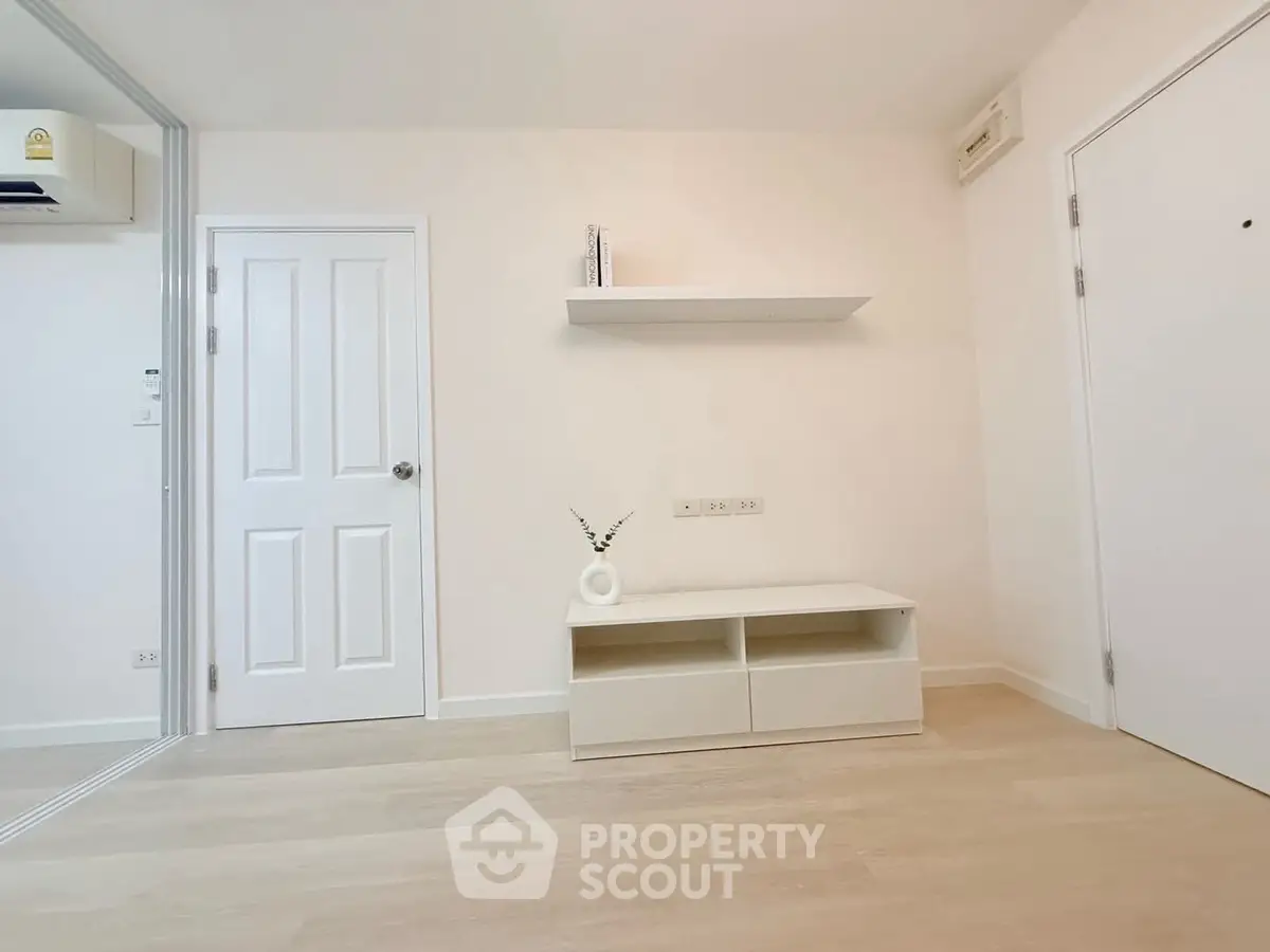 Minimalist interior with white walls, sleek shelf, and modern storage unit.