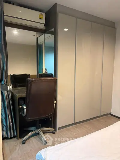 Modern bedroom with sleek wardrobe and cozy workspace