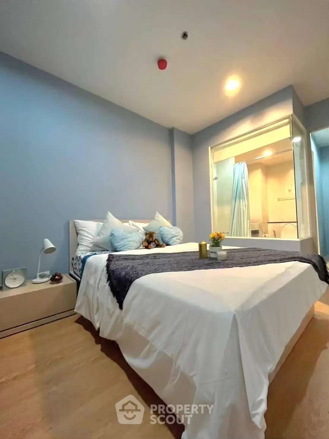 Cozy bedroom with modern decor and ensuite bathroom, perfect for relaxation.