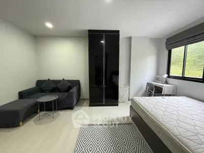 Modern studio apartment with sleek black wardrobe and cozy furnishings