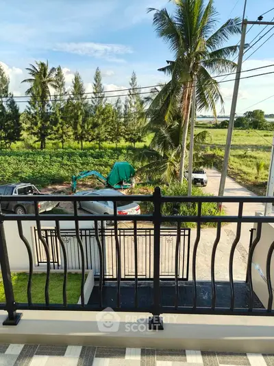 Scenic balcony view with lush greenery and palm trees, perfect for relaxation.