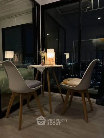 Cozy balcony with night city view, featuring modern chairs and ambient lighting.
