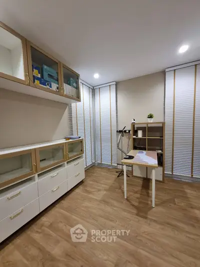 Modern study room with wooden flooring and sleek cabinetry, perfect for productivity.