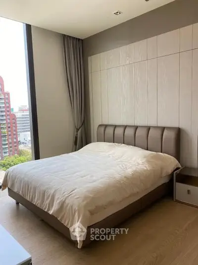 Modern bedroom with large window and stylish decor in urban apartment