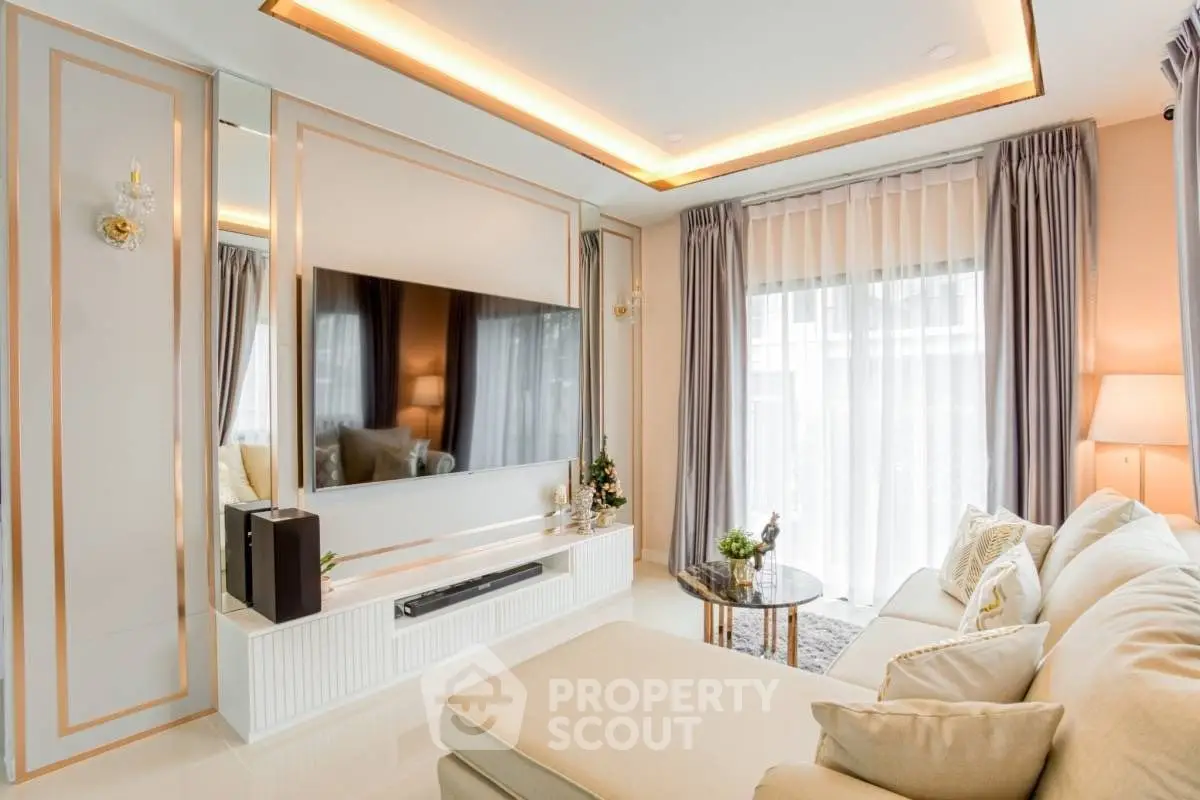 Luxurious living room with elegant decor and large TV, featuring floor-to-ceiling windows and plush seating.