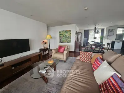 Spacious living room with modern decor and open dining area, perfect for entertaining guests.