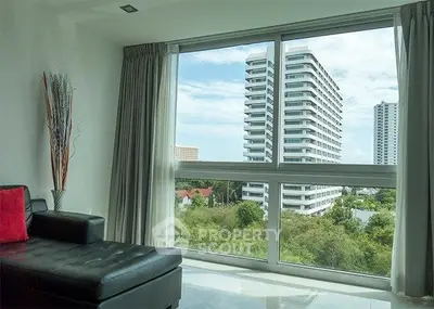 Modern living room with large window offering stunning cityscape view.