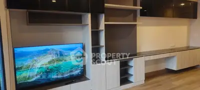 Modern living room with sleek built-in entertainment center and large flat-screen TV.