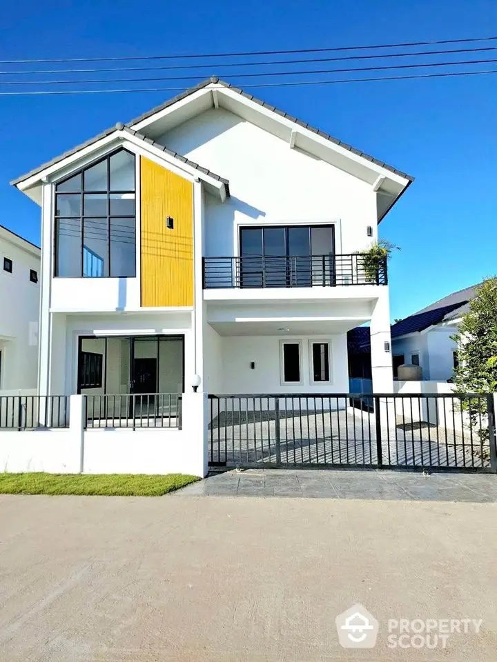 Modern two-story house with large windows and gated entrance