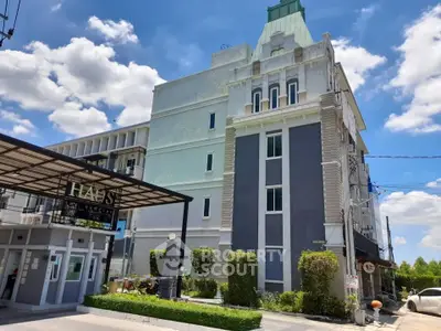Stunning modern apartment building with lush greenery and clear blue skies, perfect for urban living.