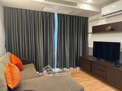 Modern living room with cozy sofa, TV, and stylish decor in a contemporary apartment.