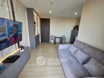 Modern living room with sleek design, featuring a cozy sofa, wall-mounted TV, and stylish shelving unit.