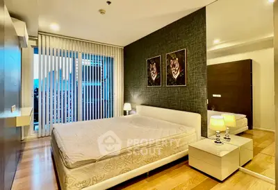 Luxurious bedroom with modern decor and city view, featuring elegant lighting and stylish wall art.