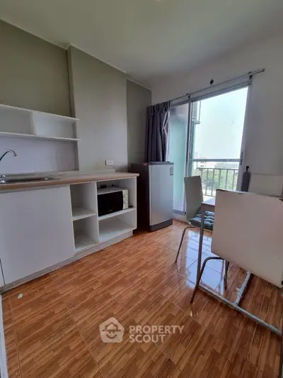 Modern kitchen with open layout and balcony view in a cozy apartment