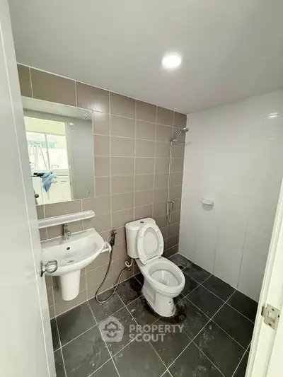 Modern bathroom with sleek tiles and contemporary fixtures in a real estate property.
